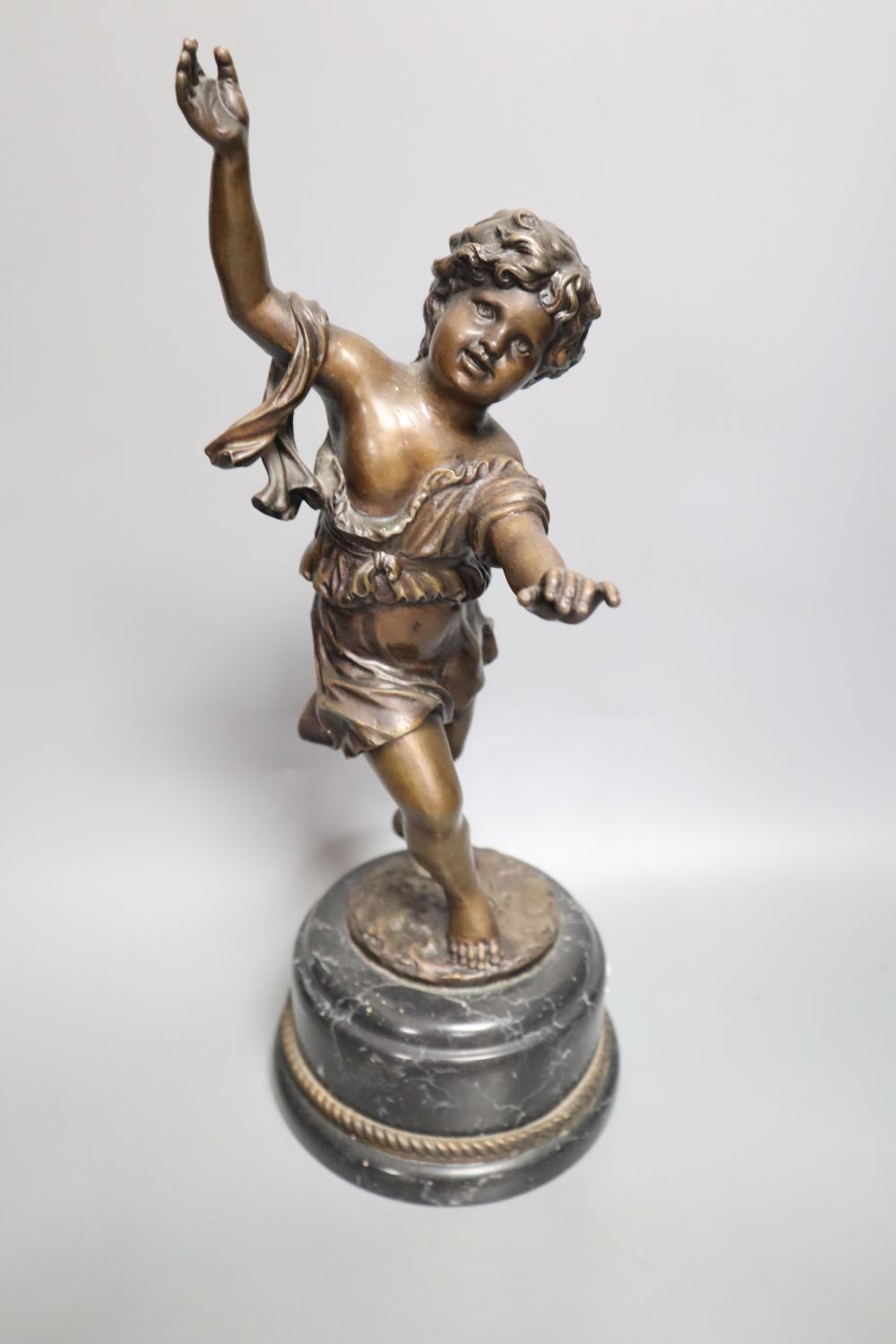 A pair of late 19th century painted bronze labourer figures after Debut, 12in., and a bronze figure of a playful girl, on marble plinth